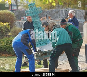Wernigerode, Deutschland. 08.. November 2022. Mitarbeiter laden ein Modell des St. Josephs Kreuzes. Im Miniaturpark endete am 06. November die Besuchersaison. Die Modelle zahlreicher Harzer Sehenswürdigkeiten werden in den kommenden Tagen gelagert. Bis zur Eröffnung der Saison im nächsten Jahr werden die durch das Wetter verursachten Schäden repariert. Im Laufe des Jahres konnten mehr als 130000 Besucher im Bürger- und Miniaturpark begrüßt werden. Quelle: Matthias Bein/dpa/Alamy Live News Stockfoto