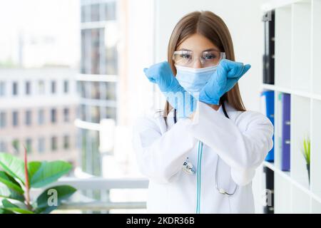 Junge europäische Ärztin, die die Arme kreuzt und negative Zeichen tut Stockfoto