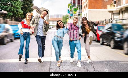 Multikulturelle trendige Freunde, die im Stadtzentrum spazieren und lustige verrückte Moves spielen - cooles Lifestyle-Konzept mit jungen Studenten Jungs und Mädchen hav Stockfoto