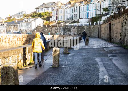 Porthleven,Cornwall,8.. November 2022,die Leute gingen trotz der extrem starken Winde in Porthleven, Cornwall, spazieren. Die Wellen waren etwa 16 Fuß mit rauer See und die Temperatur war 12C, die Vorhersage ist für Regen und starke Winde für heute.Quelle: Keith Larby/Alamy Live News Stockfoto