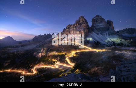 Leichte Autowege auf der Bergstraße und hohe Felsen in der Nacht Stockfoto