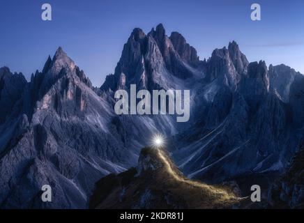 Taschenlampe Wanderwege auf Bergpfad gegen hohe Felsen in der Nacht Stockfoto