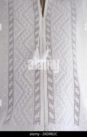 Wyschywanka - ukrainische Nationalkleid. Herrenhemd, Stickerei mit weißen Fäden auf Weiß, Unschärfe und selektiver Fokus. Kreuzstich, geometrisches Ornament Stockfoto