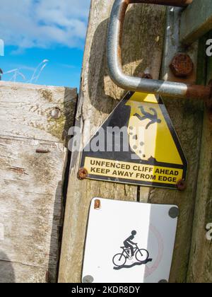 Warnschild für eine nicht eingezäunte Klippe am Südwestküstenweg zwischen Port Isaac und Polzath in Cornwall, Großbritannien. Stockfoto