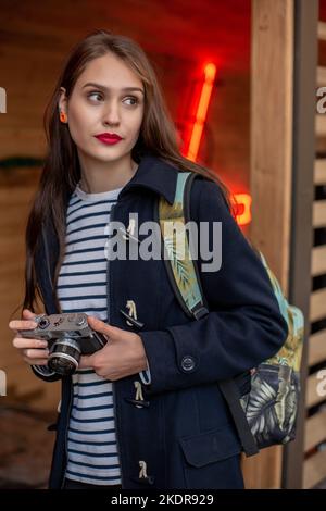 Glückliche junge Hipster Frau hält retro Foto Kamera Stockfoto