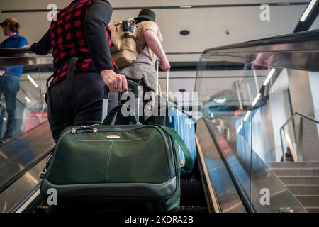 Reisende mit Gepäck betreten am Donnerstag, den 27. Oktober 2022, die Moynihan Train Hall am Bahnhof Pennsylvania in New York mit einer Rolltreppe. (© Richard B. Levine) Stockfoto