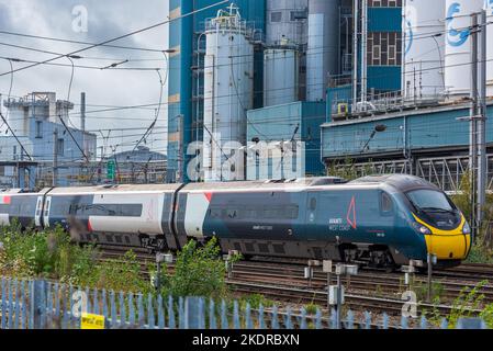 Avanti Pendolino Zug am Bahnhof Warrington Bank Quay vor der geschlossenen Fabrik Lever Faberge. Stockfoto