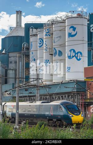 Avanti Pendolino Zug am Bahnhof Warrington Bank Quay vor der geschlossenen Fabrik Lever Faberge. Stockfoto