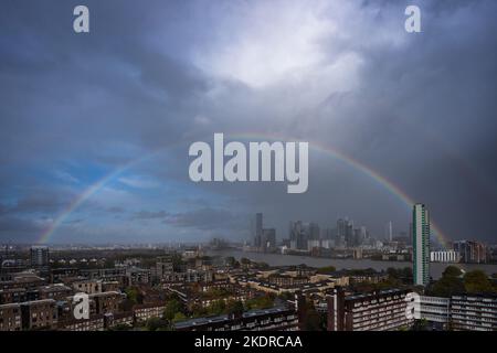 London, Großbritannien. 8.. November 2022. Wetter in Großbritannien: Ein massiver Regenbogen bricht über den Gebäuden des Canary Wharf Business Parks im Osten Londons während der fortlaufenden schweren Regenfälle. Kredit: Guy Corbishley/Alamy Live Nachrichten Stockfoto
