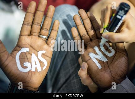 Charm El Scheich, Ägypten. 08.. November 2022. Ein Klimaaktivist der Fridays for Future-Bewegung schreibt auf der UN-Weltklimakonferenz "No Gas" auf Palmen. In Ägypten verbringen fast 200 Länder zwei Wochen damit, zu verhandeln, wie der Kampf gegen die Klimakrise beschleunigt werden kann. Quelle: Michael Kappeler/dpa/Alamy Live News Stockfoto