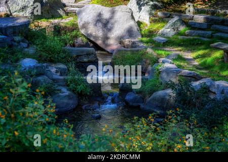 Stony Brook fließt sanft über Felsen in der Nähe der gleichnamigen Grist Mill. Stockfoto