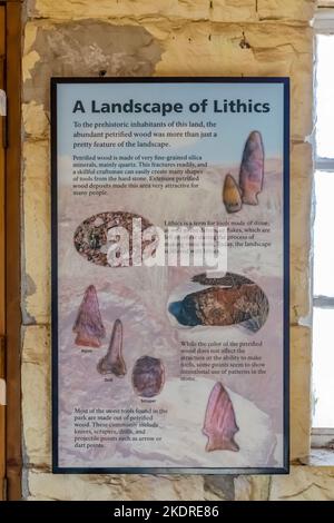 Interpretationsschild über versteinerte Holzwerkzeuge an der archäologischen Stätte von Puerco Pueblo im Petrified Forest National Park, Arizona, USA Stockfoto