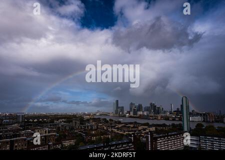 London, Großbritannien. 8.. November 2022. Wetter in Großbritannien: Ein massiver Regenbogen bricht über den Gebäuden des Canary Wharf Business Parks im Osten Londons während der fortlaufenden schweren Regenfälle. Kredit: Guy Corbishley/Alamy Live Nachrichten Stockfoto