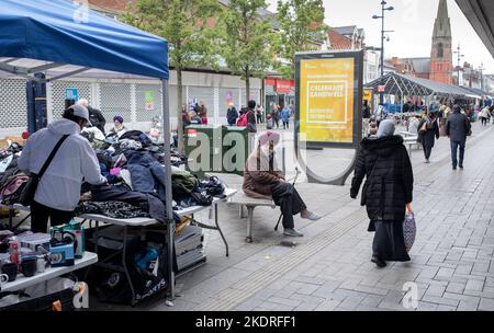 Ein älterer Sikh-Mann, der auf einer Bank am Markt in der West Bromwich High Street sitzt.