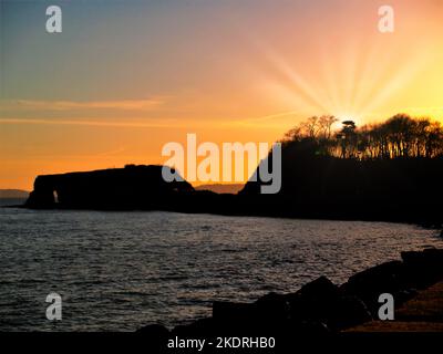 Langstone Rock, lokal bekannt als 'Red Rock' an der Küste von South Devon zwischen Dawlish Warren & Dawlish mit der untergehenden Sonne dahinter. Stockfoto