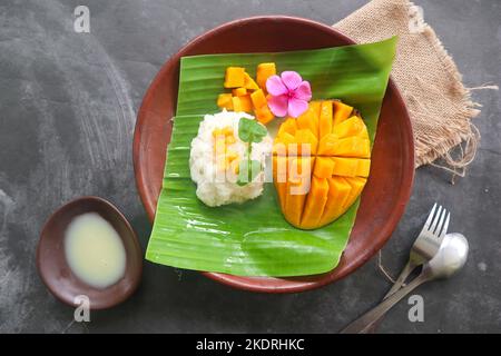 Mango Sticky Reis ist ein thailändisches Dessert aus klebrigem Reis, Mango und Kokosmilch. Stockfoto