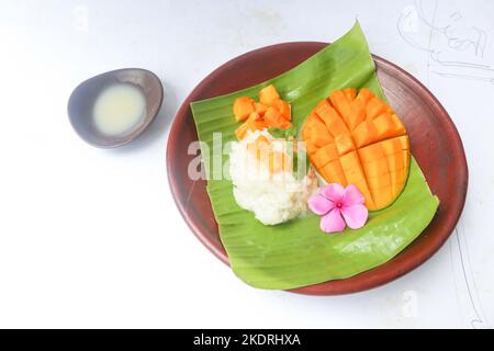 Mango Sticky Reis ist ein thailändisches Dessert aus klebrigem Reis, Mango und Kokosmilch. Isoliert auf weißem Hintergrund Stockfoto