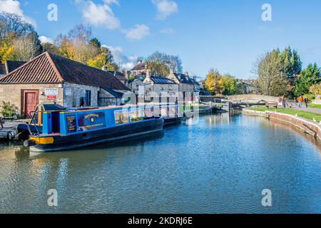 Der Bradford- und Avon-Kanal bei Bradford auf Avon in West Wiltshire mit einem Schmalboot, das in der Nähe der Brücke und der Schleusentore festgemacht wurde Stockfoto