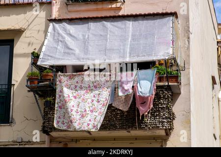Bild einer trocknenden Kleidung auf dem Balkon eines italienischen Appartements in der Nähe der Bahngleise, aber ohne Garten. Stockfoto