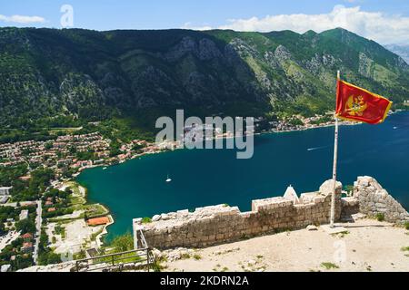 Die Flagge Montenegros entwickelt sich im Wind. Blick von der Festung Kotor Stockfoto