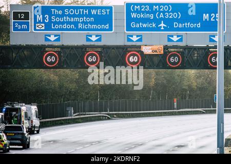 Thorpe, Großbritannien. 8.. November 2022. Ein „Just Stop Oil“-Banner ist während eines Protestes auf einer Überkopfbrücke über der Autobahn M25 zwischen den Kreuzungen 12 und 13 abgebildet. Just Stop Oil stoppte den Verkehr an mehreren Standorten am M25 für einen zweiten Tag als Teil ihrer Kampagne, um zu fordern, dass die Regierung alle neuen Öl- und Gaslizenzen einstellt und einwilligt. Kredit: Mark Kerrison/Alamy Live Nachrichten Stockfoto