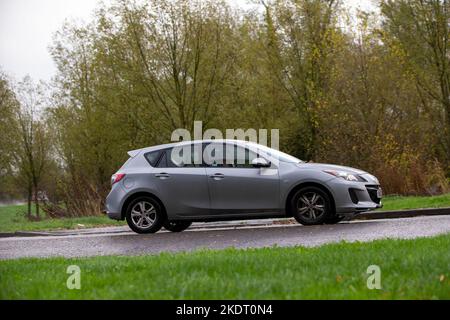2012 Mazda 3 Estate Auto Fahren im Regen auf einer nassen Straße Stockfoto