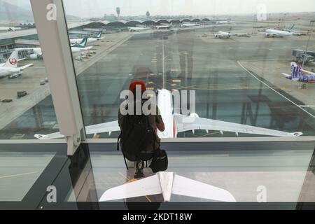 Ein Fotograf fotografiert als Flugzeug vorbei an der neu eröffneten Sky Bridge des Hong Kong International Airport in Chek Lap Kok.Sky Bridge, einer Fußgängerbrücke zwischen Terminal 1 und der T1 Satellite Concourse am Hong Kong International Airport, Und nehmen den Betrieb am 1. November auf, um den Passagieren ein komfortableres und bequemeres Flughafenerlebnis zu bieten. 01NOV22 SCMP/Yik Yeung-man Stockfoto