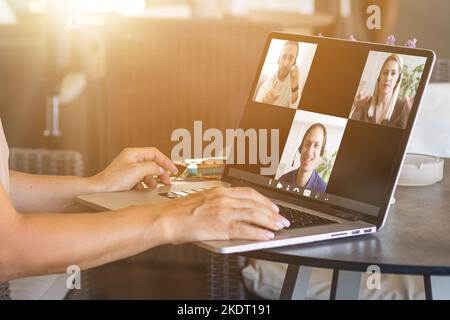 Rückansicht einer Mitarbeiterin, die an einer Webcam-Konferenz auf einem Laptop teilgenommen hat, eine Online-Briefing oder eine Konsultation von zu Hause aus durchgeführt hat, eine Mitarbeiterin spricht darüber Stockfoto