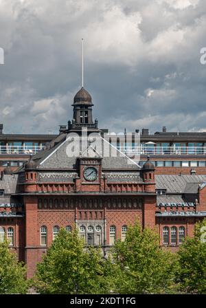 Helsinki, Finnland - 19. Juli 2022: Zentraler Teil des historischen, roten Backsteins Zollhaus mit Uhrenturm über dem Eingang zu Büros und Lager unter da Stockfoto