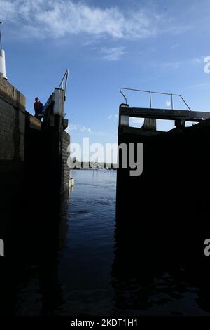 Schmale Boote, die durch die Schleuse fahren. Tore öffnen sich Stockfoto