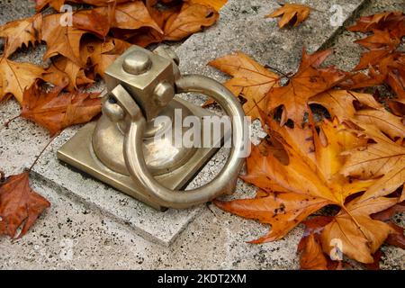 Friedhof Grabdeckel Griff Herbst gelbes Blatt Stockfoto