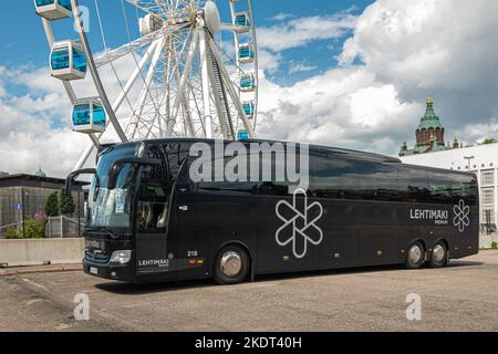 Helsinki, Finnland - 19. Juli 2022: Nahaufnahme eines schwarzen luxuriösen Touristenbusses, Reisebusses, Parket vor dem Skywheel, Riesenrad-Attraktion. Turm von Uspen Stockfoto