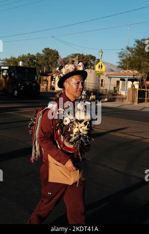 Tucson, Arizona, USA. 6.. November 2022. Die alljährliche All Souls Prozession 33. in Tucson, Arizona. Gesponsert von der gemeinnützigen Many Mouls to Feed Hunderttausende von Teilnehmern und Zuschauern versammeln sich, um sich an die Angehörigen und Freunde zu erinnern und sie zu ehren, die sie verloren haben. Sie trauern um ihren Tod und feiern ihr Leben und bewahren die Erinnerungen der Verstorbenen am Leben. Die Menschen kleiden sich in verzierten Kostümen, ähnlich denen, die am Tag der Toten gesehen wurden, aber die beiden Zeremonien sind nicht die gleichen. Die Marschierenden legen schriftliche Notizen in ein großes Stahlgefäß namens Urne. Die Saaldiener nehmen die Notizen und legen sie in die Urne, die ein Stockfoto