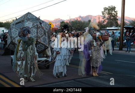 Tucson, Arizona, USA. 6.. November 2022. Die alljährliche All Souls Prozession 33. in Tucson, Arizona. Gesponsert von der gemeinnützigen Many Mouls to Feed Hunderttausende von Teilnehmern und Zuschauern versammeln sich, um sich an die Angehörigen und Freunde zu erinnern und sie zu ehren, die sie verloren haben. Sie trauern um ihren Tod und feiern ihr Leben und bewahren die Erinnerungen der Verstorbenen am Leben. Die Menschen kleiden sich in verzierten Kostümen, ähnlich denen, die am Tag der Toten gesehen wurden, aber die beiden Zeremonien sind nicht die gleichen. Die Marschierenden legen schriftliche Notizen in ein großes Stahlgefäß namens Urne. Die Saaldiener nehmen die Notizen und legen sie in die Urne, die ein Stockfoto