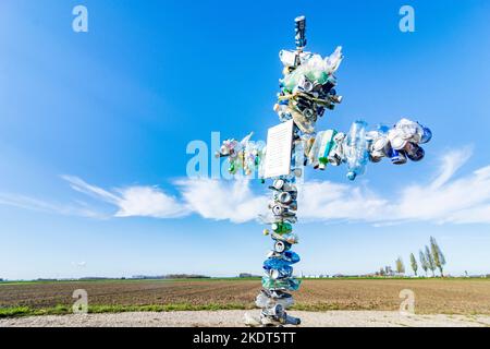 Kreuz aus ausrangierten Dosen und Flaschen, um die Menschen beim Umweltschutz in Donau, Niederösterreich, Niederösterreich, Österreich, zu erinnern Stockfoto