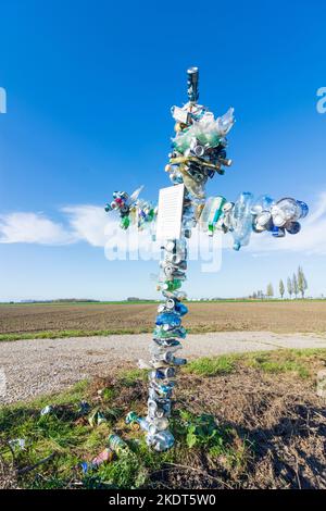 Kreuz aus ausrangierten Dosen und Flaschen, um die Menschen beim Umweltschutz in Donau, Niederösterreich, Niederösterreich, Österreich, zu erinnern Stockfoto