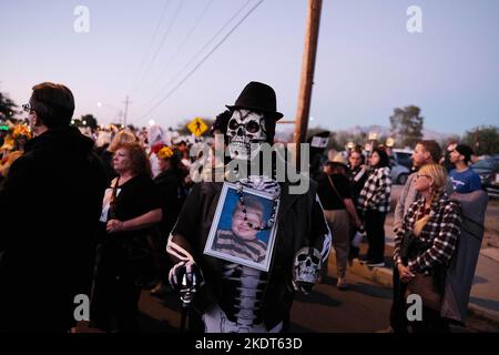 Tucson, Arizona, USA. 6.. November 2022. Die alljährliche All Souls Prozession 33. in Tucson, Arizona. Gesponsert von der gemeinnützigen Many Mouls to Feed Hunderttausende von Teilnehmern und Zuschauern versammeln sich, um sich an die Angehörigen und Freunde zu erinnern und sie zu ehren, die sie verloren haben. Sie trauern um ihren Tod und feiern ihr Leben und bewahren die Erinnerungen der Verstorbenen am Leben. Die Menschen kleiden sich in verzierten Kostümen, ähnlich denen, die am Tag der Toten gesehen wurden, aber die beiden Zeremonien sind nicht die gleichen. Die Marschierenden legen schriftliche Notizen in ein großes Stahlgefäß namens Urne. Die Saaldiener nehmen die Notizen und legen sie in die Urne, die ein Stockfoto