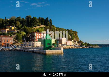 Piran, Slowenien - September 17. 2022. Ein kleiner grüner Leuchtturm am Ufer der historischen mittelalterlichen Stadt Piran an der slowenischen Küste Stockfoto