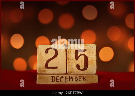 Weihnachten dezember 25 vintage Holzblock Kalender auf rotem Stoff, festliche Bokeh Lichter Hintergrund Grußkarte Geburtstag feiern, speichern Sie das Datum, Stockfoto