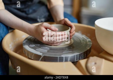 Nahaufnahme einer jungen Frau mit Töpferscheibe und Erstellung handgefertigter Keramik in gemütlichen Studio, Copy Space Stockfoto