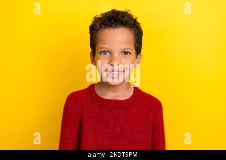 Foto Porträt von niedlichen kleinen Jungen toothy strahlend Lächeln Shopping Banner tragen trendige rote Strickmode Outfit isoliert auf gelbem Hintergrund Stockfoto