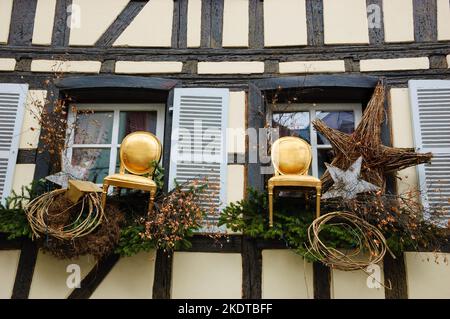 STRASSBURG, FRANKREICH - 21. DEZEMBER 2015: Weihnachtliche rustikale Dekoration mit Stühlen und Korbsternen auf dem Restaurantgebäude in der mittelalterlichen Stadt Straßburg Stockfoto