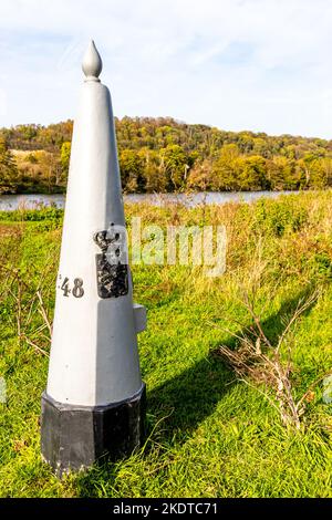 Eijsder Beemden Naturschutzgebiet mit Grenzmarkierung zwischen Belgien und Holland, Fluss Maas, Waldlandschaft im Hintergrund, Herbsttag in Eijsden, S Stockfoto