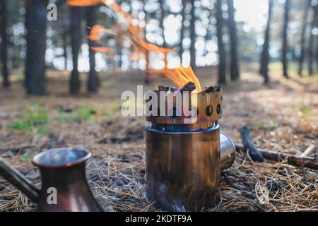 Tragbarer Holzofen im Wald. Kaffeeprozess am Lagerfeuer. Stockfoto