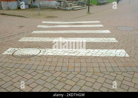 Fußgängerübergang auf einer kleinen asphaltierten Straße. Sichere Fußgänger-Bewegung. Stockfoto