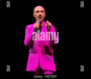 Komiker Rob Madge in pinkem Anzug, der während des Edinburgh Festival Fringe, Schottland, Großbritannien, auf der Bühne auftrat Stockfoto