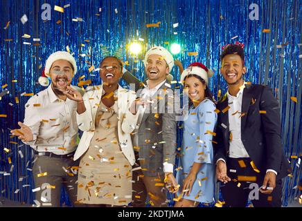 Fröhliche, schöne junge, multirassische Freunde, die gemeinsam Spaß auf der Neujahrsfeier haben. Stockfoto