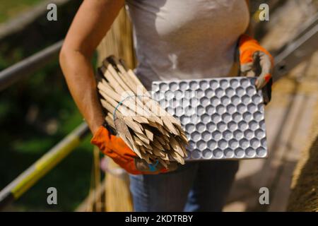 Bild von Jim Wileman - Jane Rush, aufgenommen auf der Lower Jurston Farm, in der Nähe von Chagford, Devon. Jane stroht auf ihrem eigenen Dach. Stockfoto