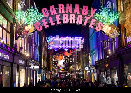 NUR FÜR REDAKTIONELLE VERWENDUNG Allgemeine Ansichten der diesjährigen Weihnachtsinstallation Carnaby Celebrates mit dem Titel Carnaby Celebrates, in Zusammenarbeit mit dem diesjährigen Charity-Partner Choose Love, mit einer Mischung aus kultigen Lichtern der letzten 25 Jahre. Bilddatum: Dienstag, 8. November 2022. Stockfoto