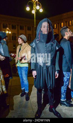 22-02-2014 Mailand, Italien. Ein sehr modischer junger Mann (sieht aus wie ein Mann, der eine Wabe aus einem Bienenstock zieht) auf der Piazza Duomo, neben dem Eingang zu o Stockfoto